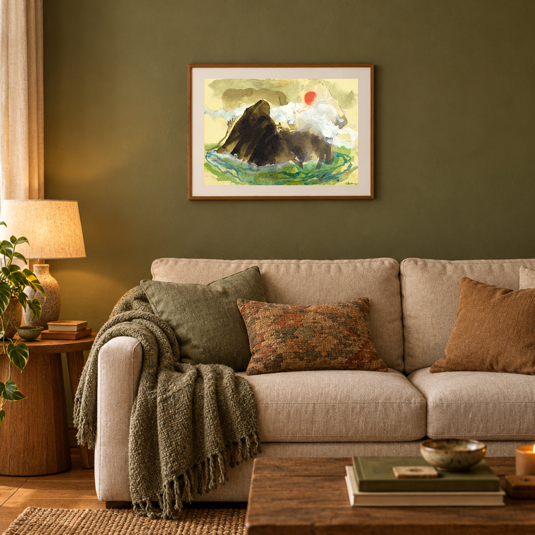 A framed limited edition print of 'Island Mist' a torn paper and watercolor artwork by Ray Marta hangs above a sofa in a comfy living room.